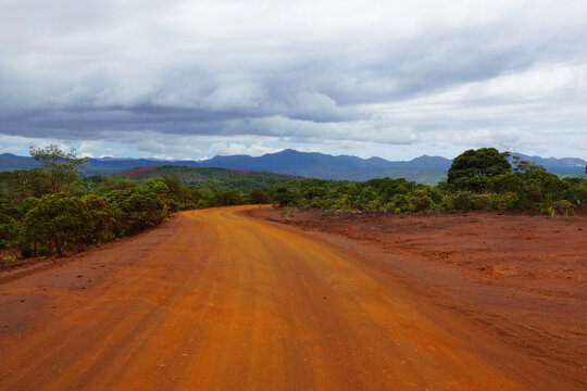 Red dusty road leading to the old Prony village in New Caledonia