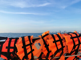 Orange life jacket important for life security in the water or the sea on blue sky background.