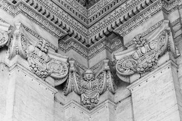 Black and white photo showing in detail sculptures carved on marble in the corner of wall inside...