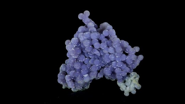 Natural stone-chalcedony spherulites (grape chalcedony) rotation on a black background.