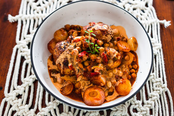 plant-based food, vegan potato and onion roast with chickpeas tomato sauce and herbs