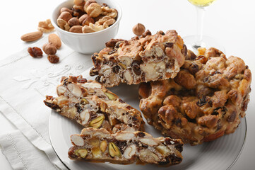Pangiallo, traditional Italian dessert with honey, candied fruit, flour and dried fruit on white...