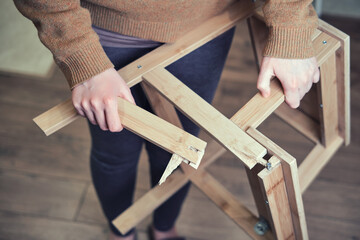 Leg of the wooden chair broke at the base. Stepladder broken in the woman hands. Problems with safety at work at home