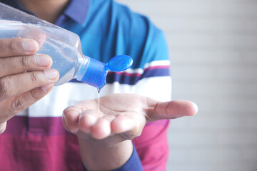 young man applying hand sanitizer gel for preventing virus 