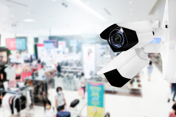 Modern public CCTV camera with blur interior shopping mall background. Recording cameras for monitoring all day and night. Concept of surveillance and monitoring with copy space.