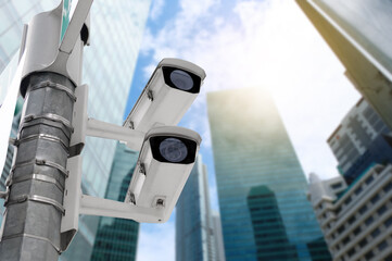 Modern public CCTV camera on electric pole with blur building background. Recording cameras for monitoring all day and night. Concept of surveillance and monitoring with copy space.