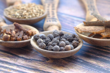 Spices and herbs on spoon on table 