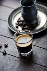 Coffee in glass cup on rustic wooden background. Close up.