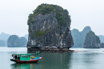 Traditional boat on the water in front of a limestone karst island in the Ha Long Bay UNESCO World Heritage site in Qiang Ninh Province in northern Vietnam
