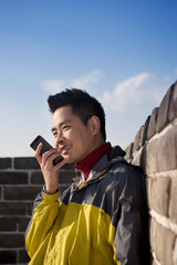 A young man use the walkie talkie in the Great Wall Tourism