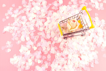 Shopping cart with rose flowers. Shopping concept. Flat lay. Copy space.