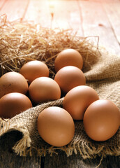 Collected chicken eggs, stacked on burlap in the chicken coop.