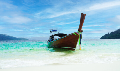 Thai traditional wooden longtail boat and beautiful sand beach at Koh lipe island.