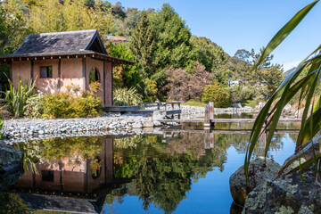 Blue sky with pond and tea house at Miyazu Japanese Garden in Nelson, South Island, New Zealand