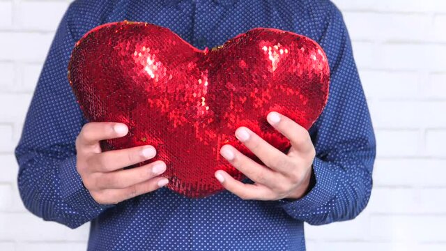 hand holding red heart symbol close up 