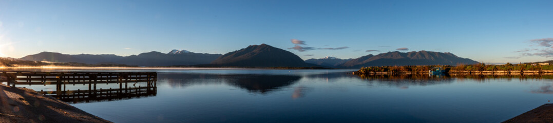 Dawn reflection of Southern Alps in calm waters at Moana, Lake Brunner, South Island, New Zealand