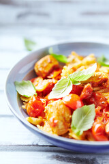 Farfalle pasta with chicken breast, cherry tomatoes and fresh basil. Bright wooden background.