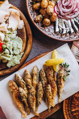 home wooden table covered with plates with various delicious dishes in the Slavic style: sourdough, salted and fried fish, potatoes, fried meat and salads