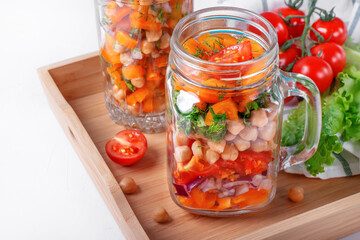 Fototapeta na wymiar Layered salad with chickpea and vegetables in mason jar