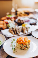 traditional russian herring salad under a fur coat and olives on a wooden table next to other festive dishes