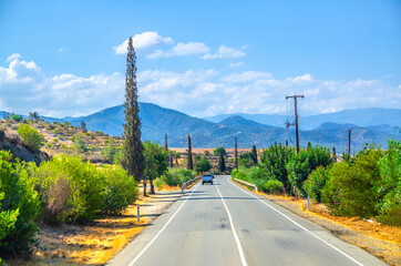 Landscape of Cyprus with cars vehicles riding asphalt road in valley with yellow dry fields,...