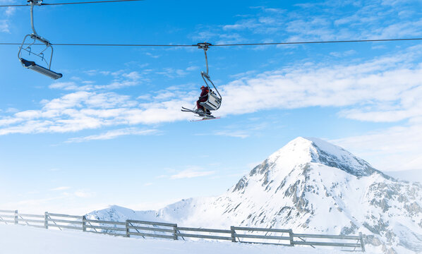 Skiers sit in chair lift.Skiers ascending on ski lift.