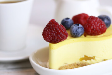light cake with raspberries and blueberries and a cup of coffee, pleasant light breakfast