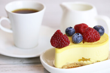 light cake with raspberries and blueberries and a cup of coffee, pleasant light breakfast