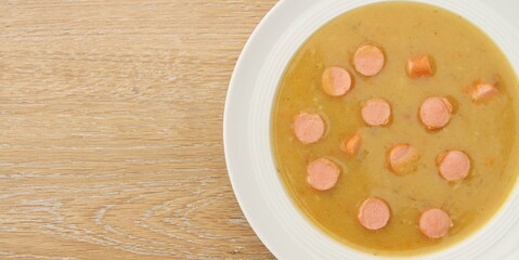 fresh potato soup with viennese sausages on a wooden board
