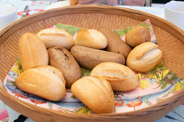 A wicker basket with assorted bread buns for lunch