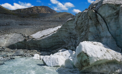 Fototapeta na wymiar mountain river rushing through the glacier, outdoor natural background