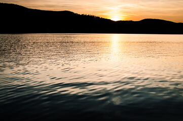 zachód słońca nad górami odbijający się w jeziorze
