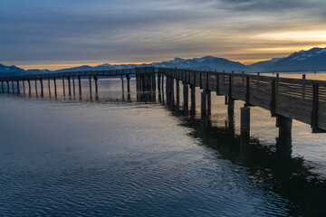 Stunning sunset view of the pedestrian wooden bridge (Holzsteg) crossing the Zurich Lake at its narrowest point between Hurden (Seedam) and Rapperswil, Switzerland