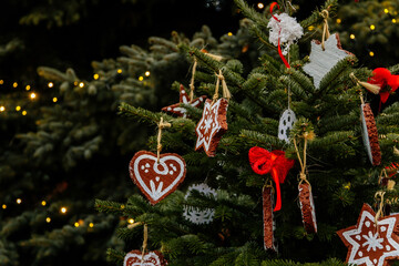 Handmade toys for Christmas tree decoration, an asterisk on green branches outdoor, toy made of wood, plaster and glitters, Environment, recycle, upcycling and zero waste concept. Selective focus