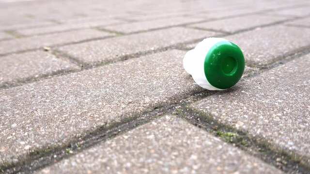 Champane Sparkling Wine Plastic Cork on Brick Sidewalk After New Year's Eve Celebration Party