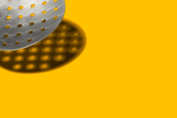 Ladle Curd Slotted Spoon with harsh shadow on yellow background. Kitchen tool, cooking utensil. Copy space.  Food concept.