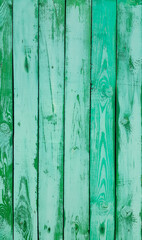 Fototapeta na wymiar Shabby weathered wooden wall painted of bright green paint