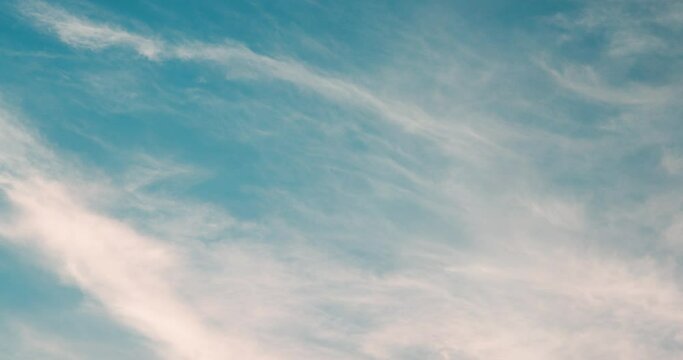 Light Clouds with Orange Sunset Sky Blending into Blue Sky at Golden Hour