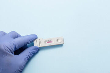 Fototapeta premium A gloved hand shows how a device to perform a sars covid 19 test at the time it begins to give a negative result.