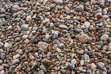 Frosted granite pebbles on the sea beach at winter