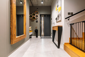 Trendy corridor with big mirror in wooden frame and console table