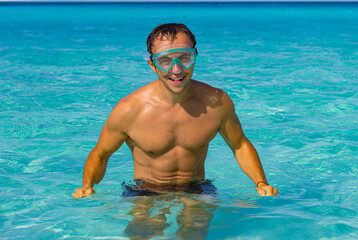 Smiling man with swimming goggles in the Caribbean sea