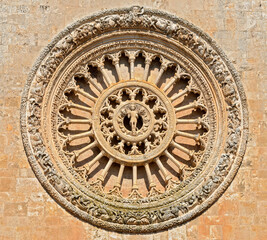 Stony rose window on the western front of the Cathedral Santa Maria Assunta in Ostuni, Italy,