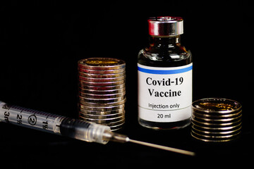 Covid-19. Concept of vaccination against new Coronavirus Covid-19.coins stack.Money-saving concept.Saving money for treatment.Selective focus on Vaccine bottle.