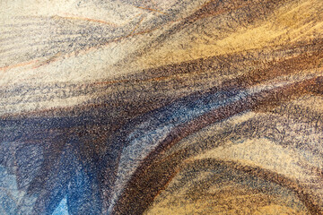 Detail einer bemalten Wand in beige, braun, blau mit grober körniger Struktur aus kleinen Steinen