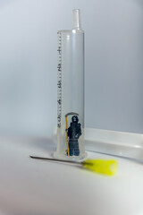 Grim Reaper figurine in a hypodermic syringe