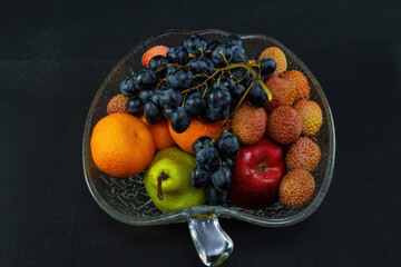 Still life in a crystal plate on a black background with a top view