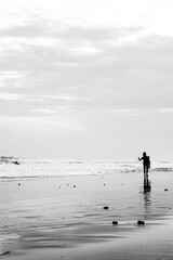 A silhouette of a female surfer throwing a hang loose sign after a good surf.