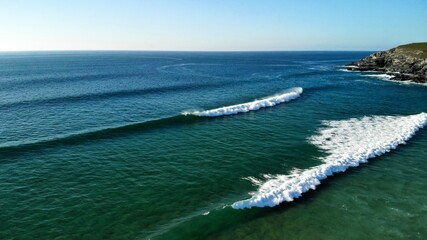 Breaking waves in the inviting blue waters of Newquay, Cornwall