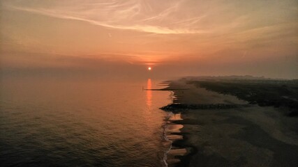 The sun reflecting off the sea water on a hazy evening at Bournemouth beach